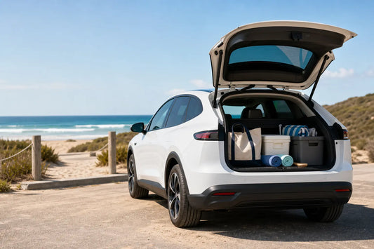 White electric crossover prepared for a beach day with organized towels, cooler, and wet-gear storage
