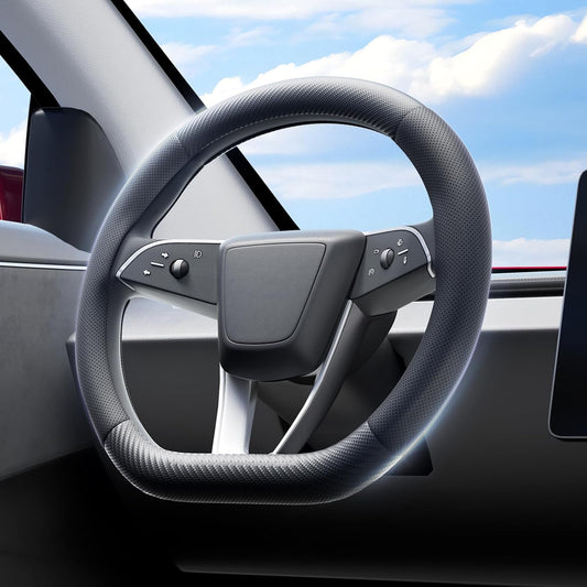 Steering wheel of a car with a clear sky visible through the window