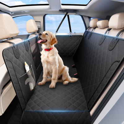 Dog sitting on a black car bench seat cover in a vehicle with a view of the sky.